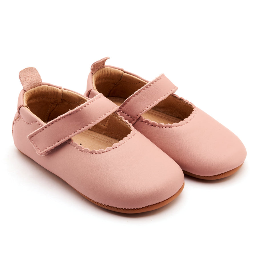 Pair of pink baby shoes with a strap on a white background