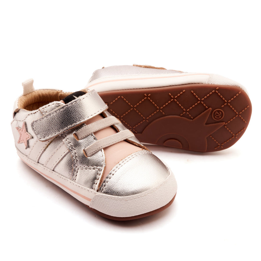 Pair of children's shoes with metallic finish on a white background