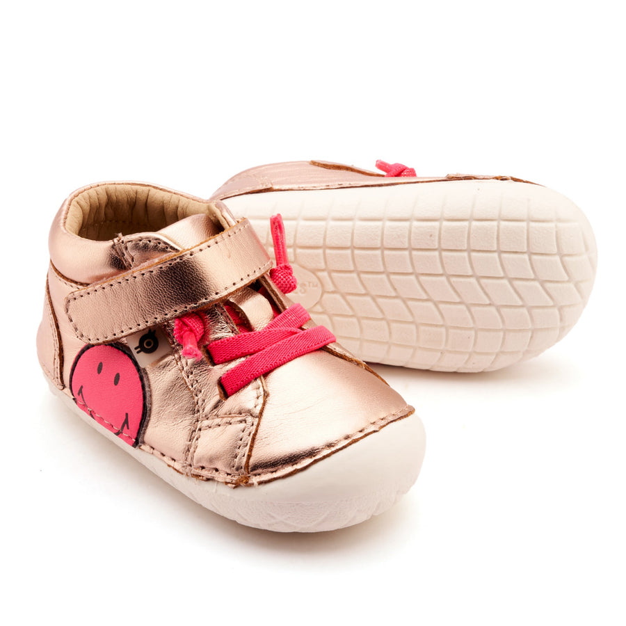 Pair of rose gold baby shoes with pink accents on a white background