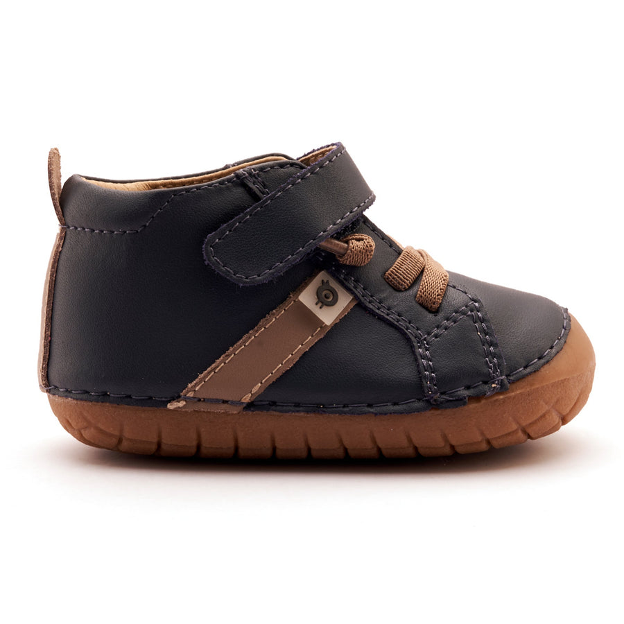 Children's black and brown shoe with a strap on a white background